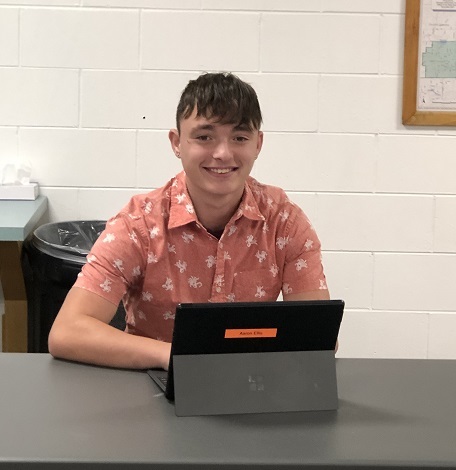 Student sitting at desk with computer.